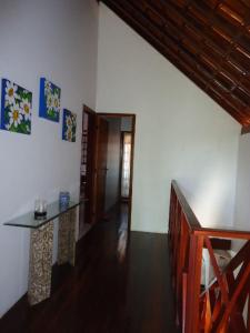 a living room with a table and a hallway at Chale 5 suites, em Condominio in Gravatá