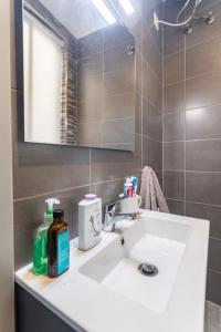 La salle de bains est pourvue d'un lavabo blanc et d'un miroir. dans l'établissement SkyView Penthouse, Mell_4, à Mellieħa