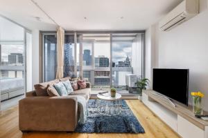 - un salon avec un canapé et une grande fenêtre dans l'établissement 'Rose Lane Retreat' Discover Melbourne City Charm, à Melbourne
