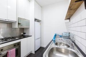 eine Küche mit einer Spüle und einem Herd in der Unterkunft A Coveted Collins Street Pad with Parking in Melbourne