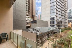 uma varanda com vista para uma cidade com edifícios altos em New York Lofted CBD Retreat with Pool and Parking em Melbourne