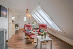 a living room with two red chairs and a table at Nordsee & Wald in Husum