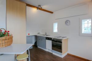 eine Küche mit weißen Wänden, einem Tisch und einem Waschbecken in der Unterkunft Nordsee & Wald in Husum