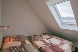 a attic bedroom with two beds and a window at Nordsee & Wald in Husum