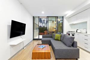 a living room with a couch and a coffee table at Carlton Delight - Patio Abode near Queen Vic Market in Melbourne