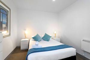 a bedroom with a large bed with two night stands at Carlton Delight - Patio Abode near Queen Vic Market in Melbourne