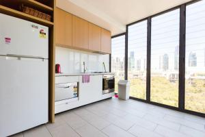 cocina con electrodomésticos blancos y ventanas grandes en Exhibition Central - Cosy CBD Queen Studio, en Melbourne