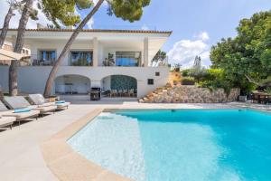 a villa with a swimming pool and a house at Villa Golf Cas Catala in Cas Català
