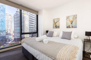 1 dormitorio con cama y ventana grande en A Modern Resort-style Stay near Crown Casino en Melbourne