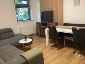 salon z kanapą, stołem i telewizorem w obiekcie Urlaub am Bauernhof - Zettlerhof Apartment 