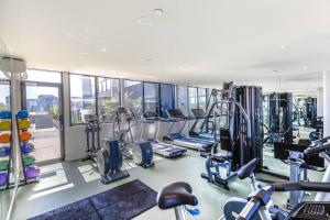 un gimnasio con varias cintas de correr y máquinas cardiovasculares en A Modern Resort-style Stay near Crown Casino en Melbourne