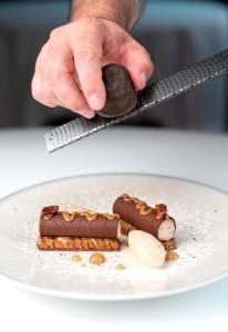 a person holding a spoon over a plate of food at InterContinental Bordeaux Le Grand Hotel by IHG in Bordeaux