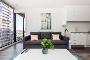 sala de estar con sofá y cocina en A Modern Resort-style Stay near Crown Casino en Melbourne