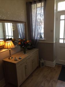 una stanza con un tavolo con una lampada e fiori di EsJays at Knowles House a Lytham St Annes