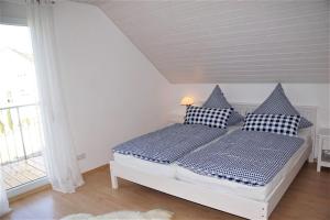 Schlafzimmer mit einem Bett mit schwarzen und weißen Kissen in der Unterkunft Ferienhaus Heck in Obernheim