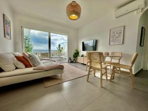 een woonkamer met een bank en een tafel en stoelen bij Las Palmas 8b Oasis Properties in Nerja