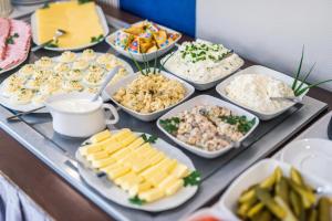 um buffet de diferentes tipos de alimentos em uma mesa em Hotel Piast Wrocław Centrum em Breslávia