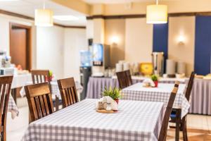 a restaurant with two tables with purple and white table cloth at Hotel Piast Wrocław Centrum in Wrocław