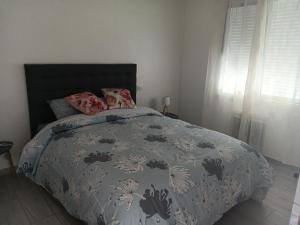 Un dormitorio con una cama con una colcha con flores. en Lesteem, en Médis