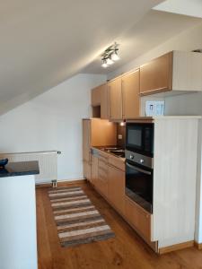 a kitchen with stainless steel appliances and wooden cabinets at Festl Apartments - Nähe Messe München, Therme Erding in Forstern