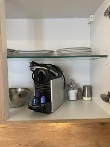 a coffee maker is sitting on a shelf in a kitchen at Festl Apartments - Nähe Messe München, Therme Erding in Forstern
