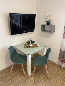 a room with a table and two chairs and a television at Festl Apartments - Nähe Messe München, Therme Erding in Forstern