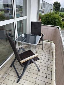a table and two chairs on a balcony at Festl Apartments - Nähe Messe München, Therme Erding in Forstern
