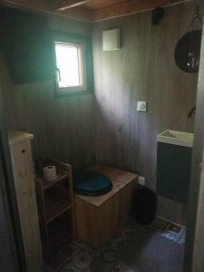a small bathroom with a toilet and a window at Tiny house in Miélan