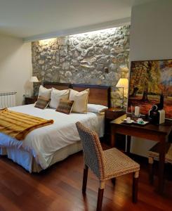 a bedroom with a bed and a table and a desk at Abadia del Pirineo in Tramacastilla de Tena