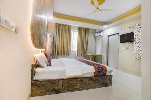 ein Hotelzimmer mit einem Bett und einem TV in der Unterkunft FabExpress Laxmi Empire, Siolim in Goa