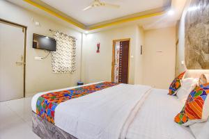 a bedroom with a large bed and a tv on the wall at FabExpress Laxmi Empire, Siolim in Goa