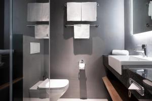 a bathroom with a toilet and a sink at IntercityHotel Wien in Vienna