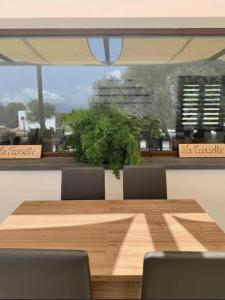 a dining room table with chairs and a large window at Agriturismo La Croisette in Dorgali