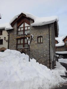 een huis met een berg sneeuw ervoor bij Abadia del Pirineo in Tramacastilla de Tena