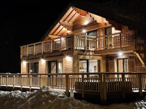 a log cabin in the snow at night at Odalys Chalet Le Chabichou in Les Deux Alpes