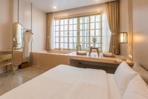 a bedroom with a large bed and a bath tub at The Elements Boutique House in Phuket Town