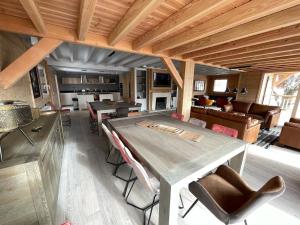 a dining room and living room with a table and chairs at Odalys Chalet Le Chabichou in Les Deux Alpes