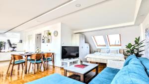 a living room with a blue couch and a table at Spacious & attractive 600m-7minuta hoda od centra, mogucnost za parking-apartmani-nsmilos in Novi Sad