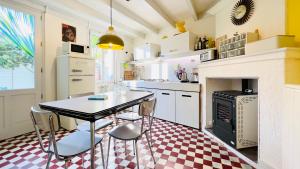 a kitchen with a table and chairs and a stove at Vintage Guesthouse in Saint-Fort-sur-Gironde