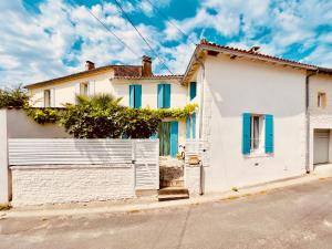 Saint-Fort-sur-GirondeにあるVintage Guesthouseの青窓・柵のある白い家