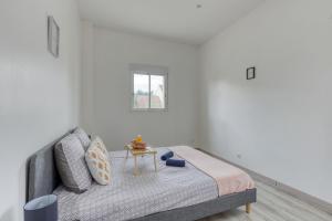 ein weißes Schlafzimmer mit einem Bett und einem Tisch in der Unterkunft Le nid cosy • Proche Disneyland in Villiers-sur-Marne