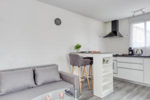 ein Wohnzimmer mit einem Sofa und einer Küche in der Unterkunft Le nid cosy • Proche Disneyland in Villiers-sur-Marne