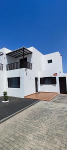 - un bâtiment blanc avec une terrasse en face dans l'établissement Villa Tingafa, à Yaiza
