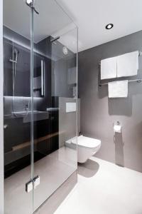 uma casa de banho com um WC e uma cabina de duche em vidro. em IntercityHotel Wien em Viena