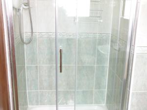 ducha con puerta de cristal junto a la bañera en Ocean View en Louisburgh