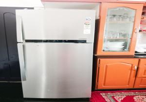 a white refrigerator in a kitchen next to a cabinet at Vaiga Homes - Vembanadu Lakeview Retreat in Cochin