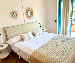 um quarto com uma cama grande e um espelho na parede em Apartamento con Piscina en Platja d'Aro by Host&Joy em Platja d'Aro