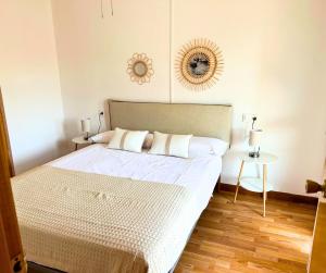 1 dormitorio con cama y espejo en la pared en Apartamento con Piscina en Platja d'Aro by Host&Joy, en Platja d'Aro