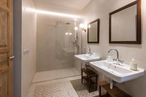 a bathroom with two sinks and a shower at Casa Pizarro Hotel in Cáceres