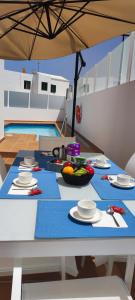 un tavolo con piatti di cibo sopra con un ombrello di Villa Tingafa a Yaiza
